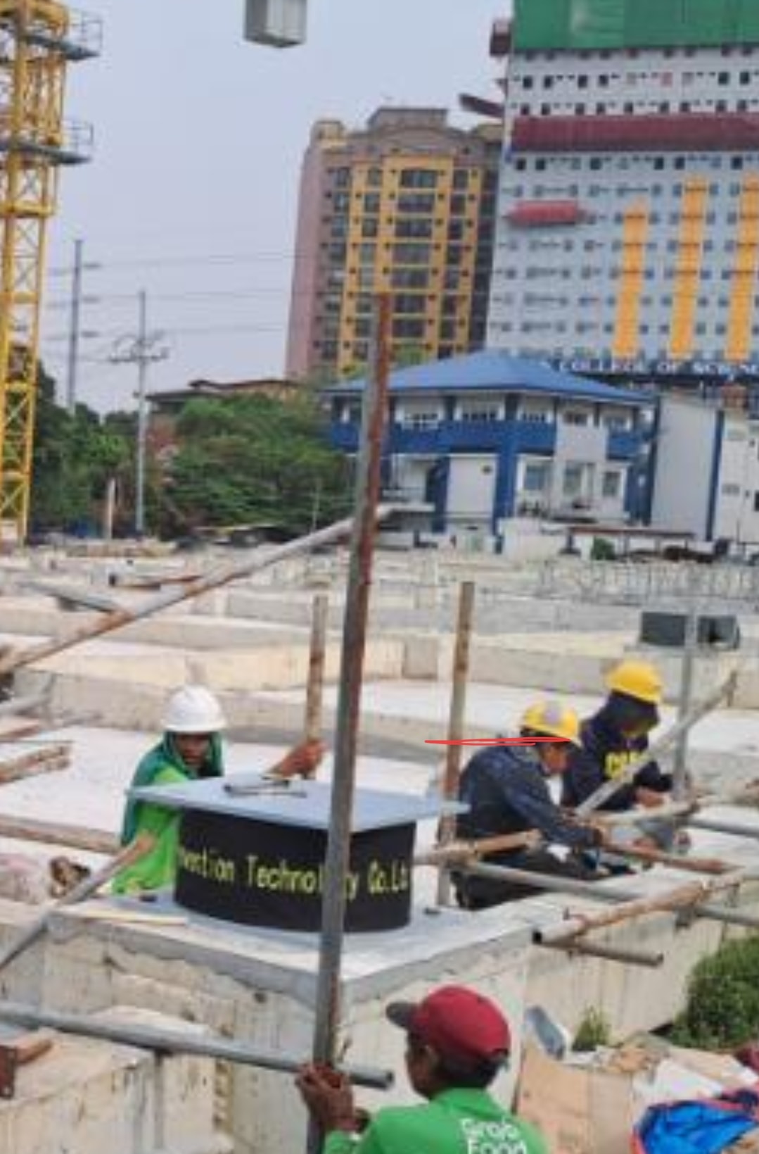 Workers installing a seismic isolation device at an urban construction site